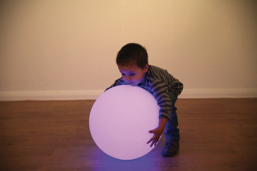 Lavender LED glow ball near a crawling child