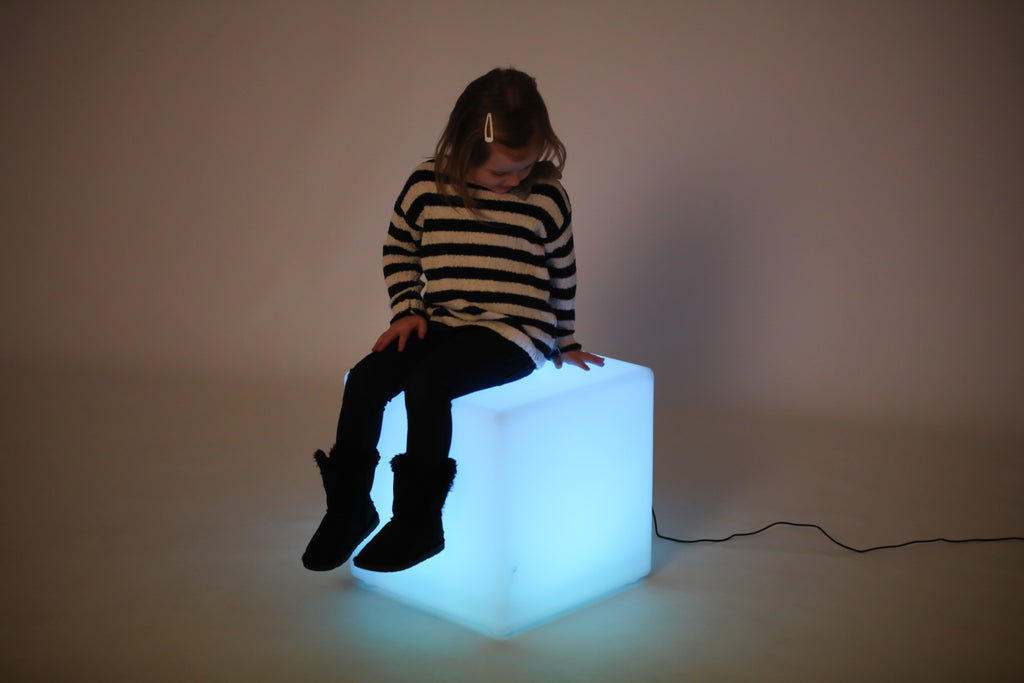Light-up cube lamp with bright blue glow, child playing beside