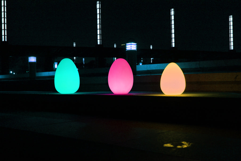 Glowing egg-shaped lights in teal, pink, and warm orange