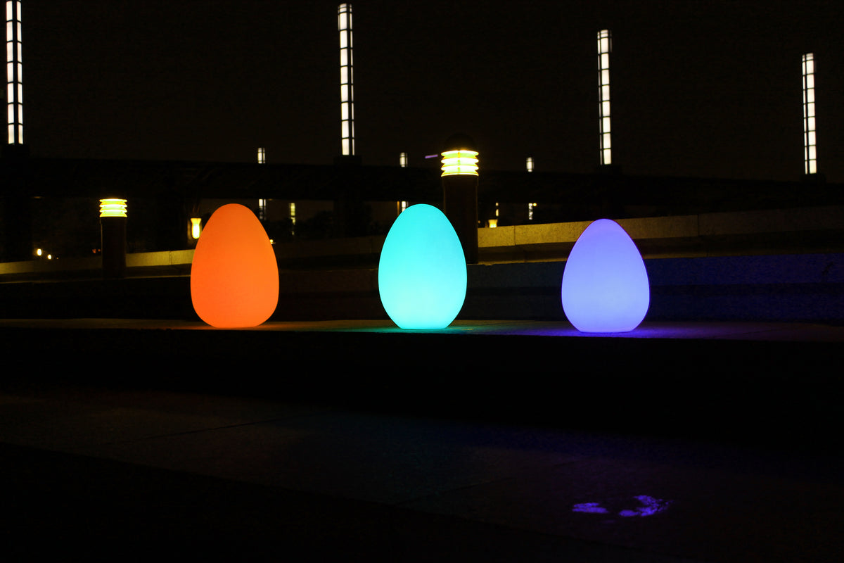 Glowing egg-shaped lights in orange, cyan, and purple-blue