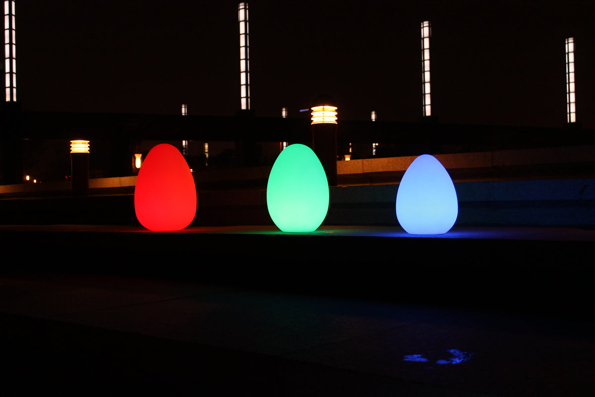 Glowing egg-shaped lights in red, green, and blue on the ground