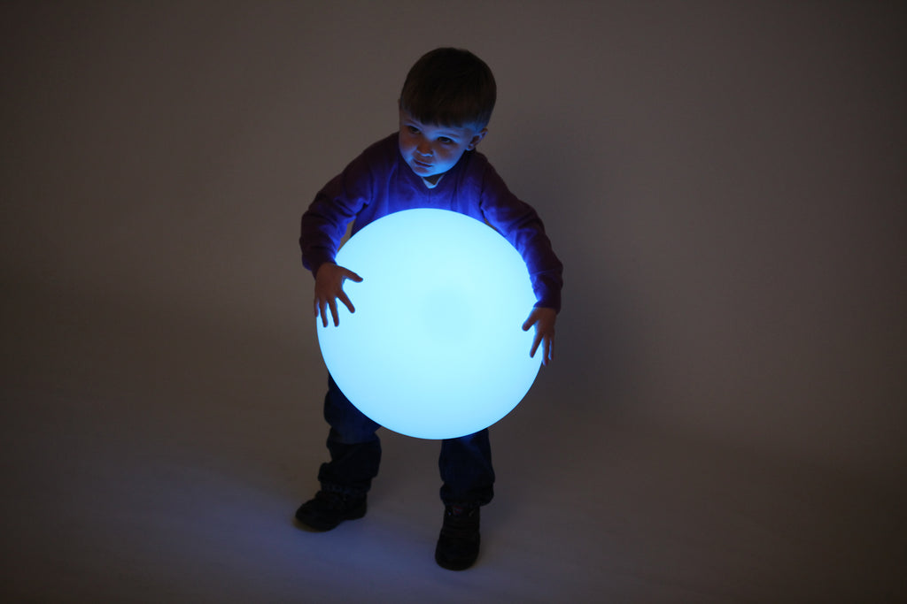 Blue glowing pebble light held by a child