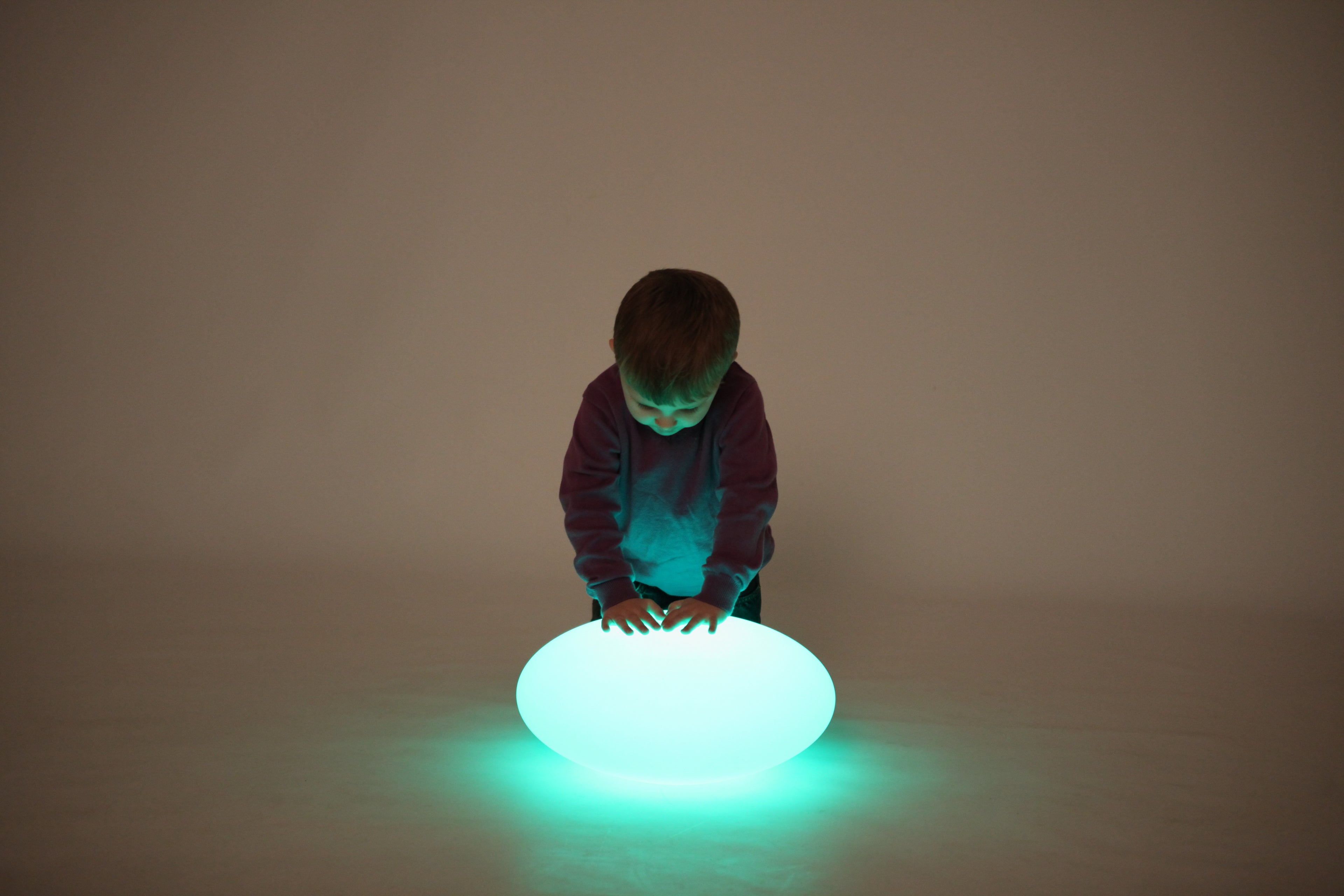 Green-lit oval glow pebble light on the floor