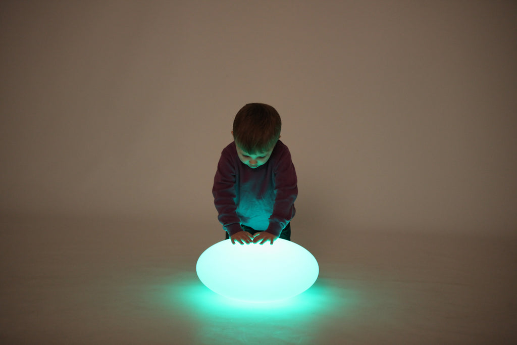 Blue-and-green glowing oval pebble light on the floor