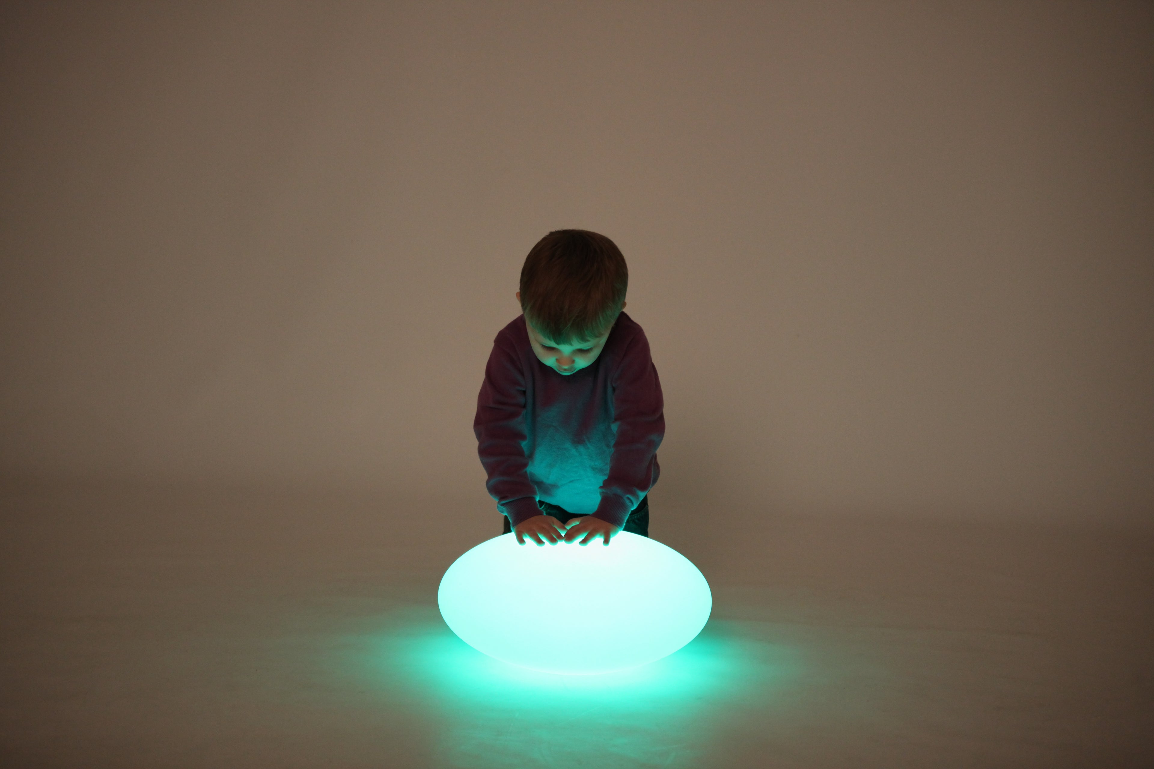 Blue-and-green glowing oval pebble light on the floor