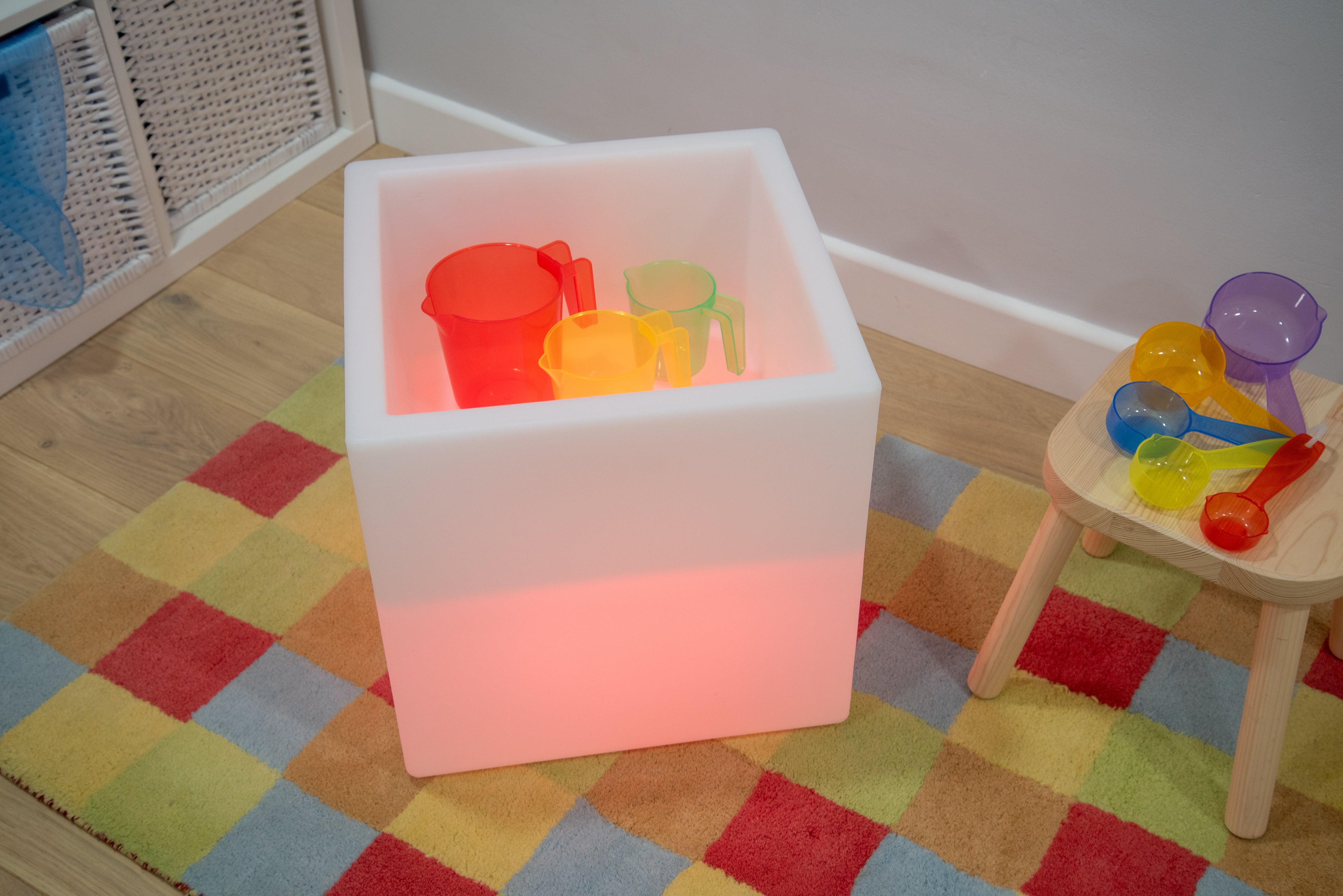 Sensory glow play cube with pink light and colorful translucent cups