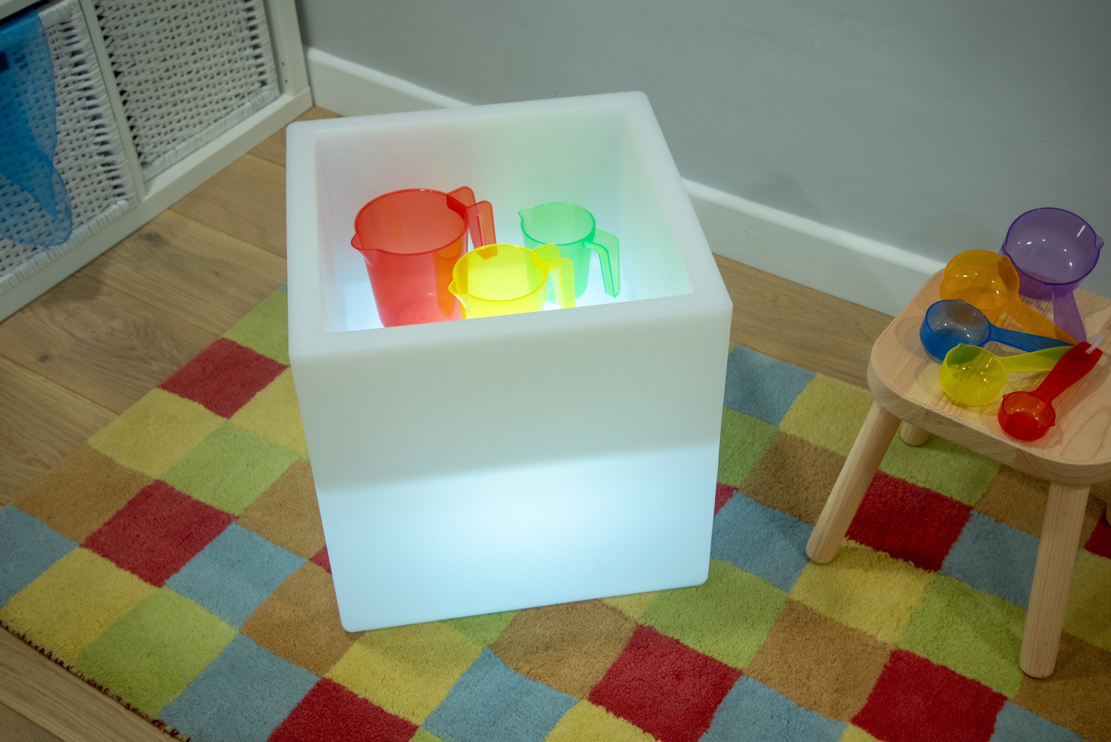 Sensory glow play cube with green light and colorful cups inside