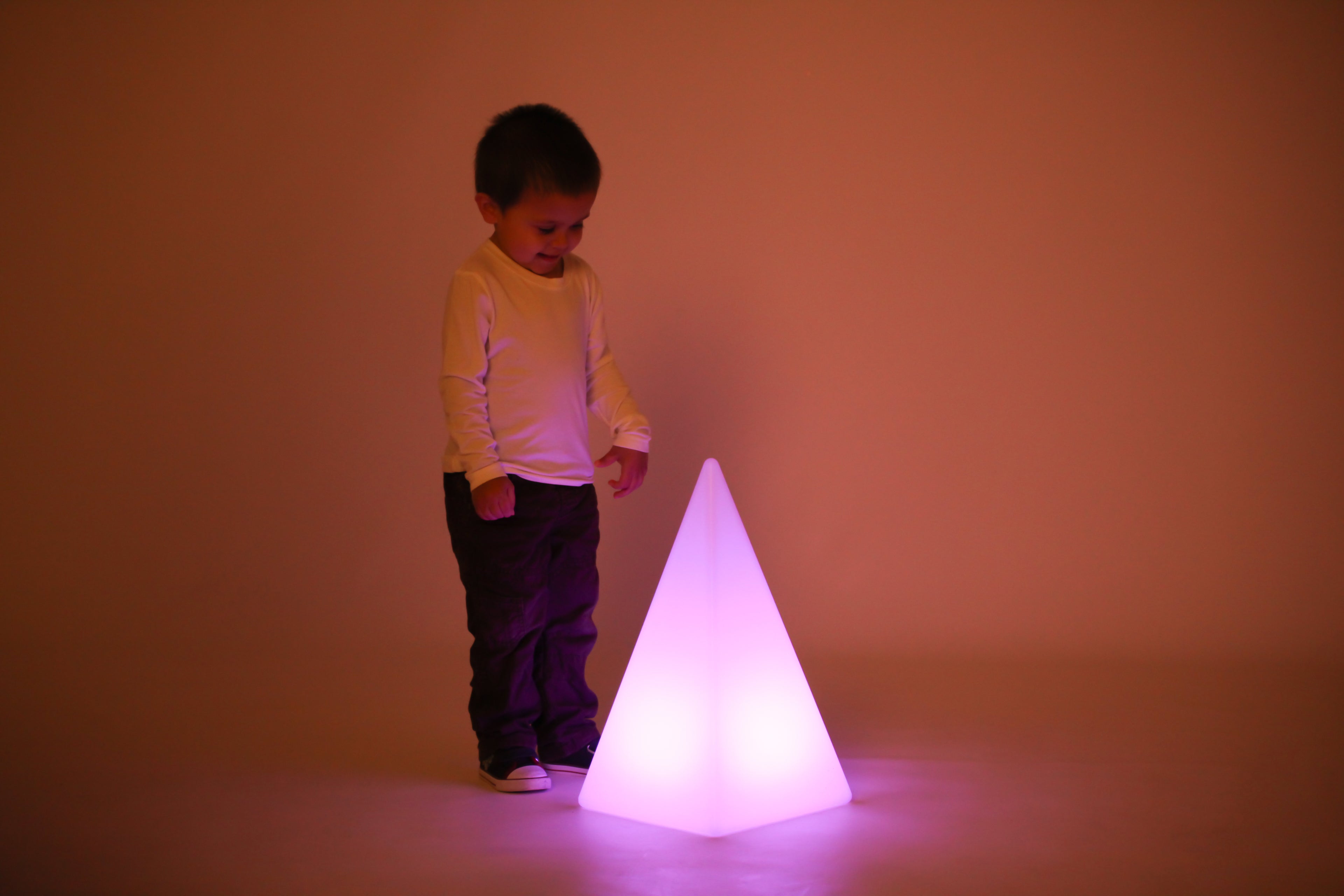 Child near glowing light pyramid, pink-purple light
