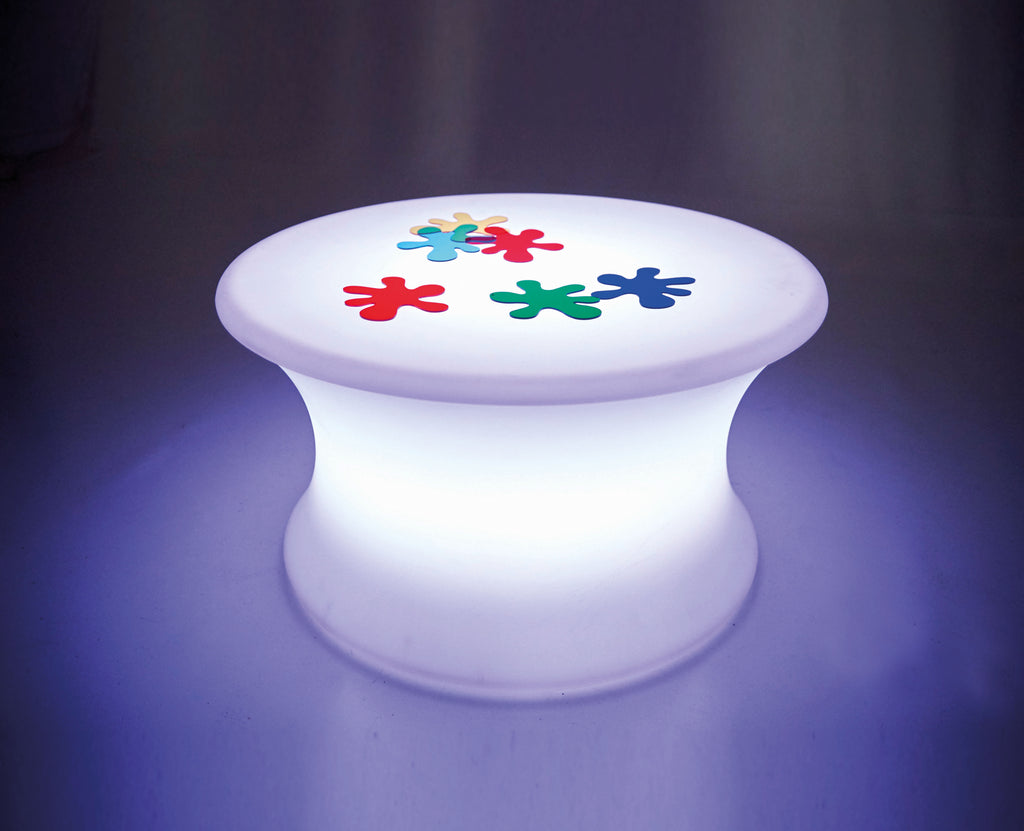 Sensory glow table with a white round top and colorful flower-shaped light graphics