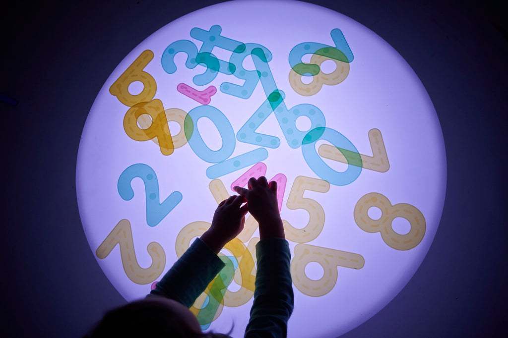 Sensory glow table with a round illuminated top showing colorful number shapes from above