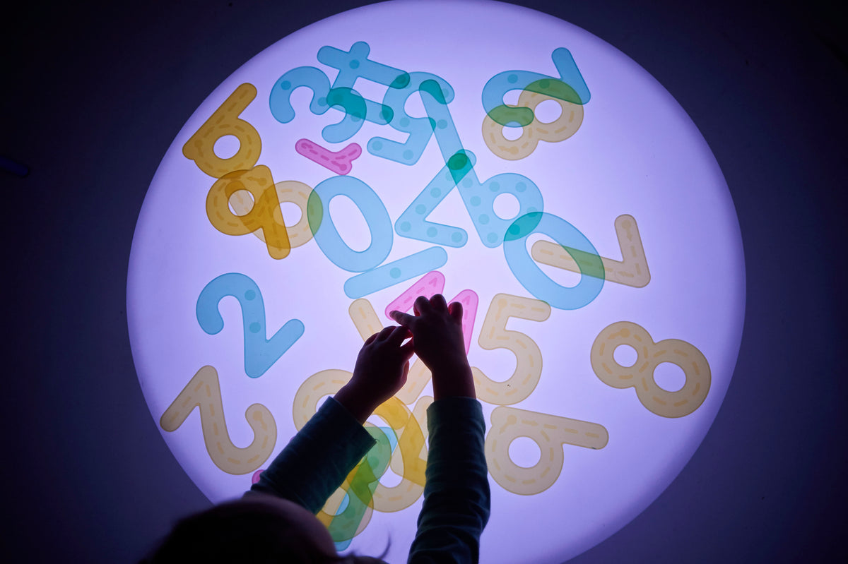 Sensory glow table with a round illuminated top showing colorful number shapes from above