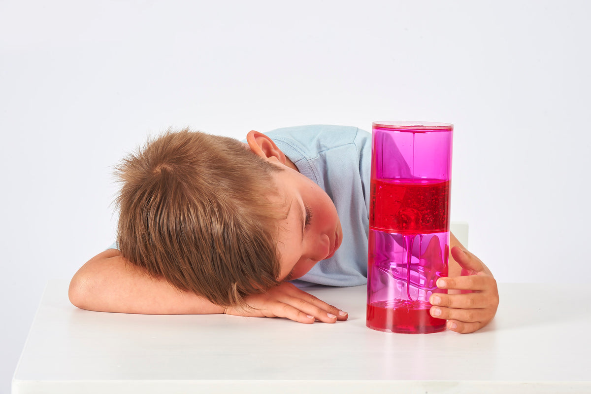 Sensory jumbo ooze tube with bright pink translucent gel, held near the face.
