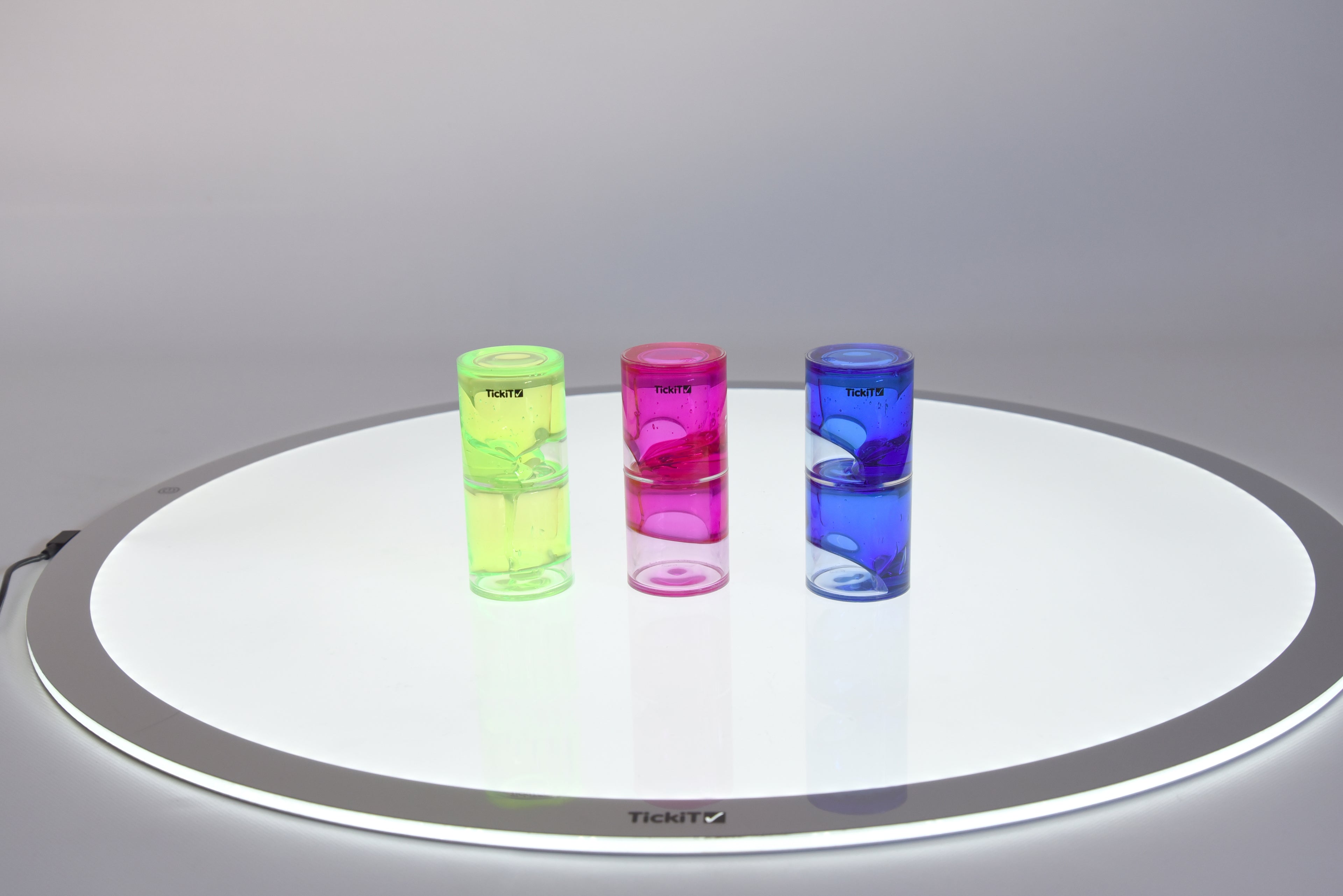 Set of three tickit ooze tubes: green, pink, and blue on round tray