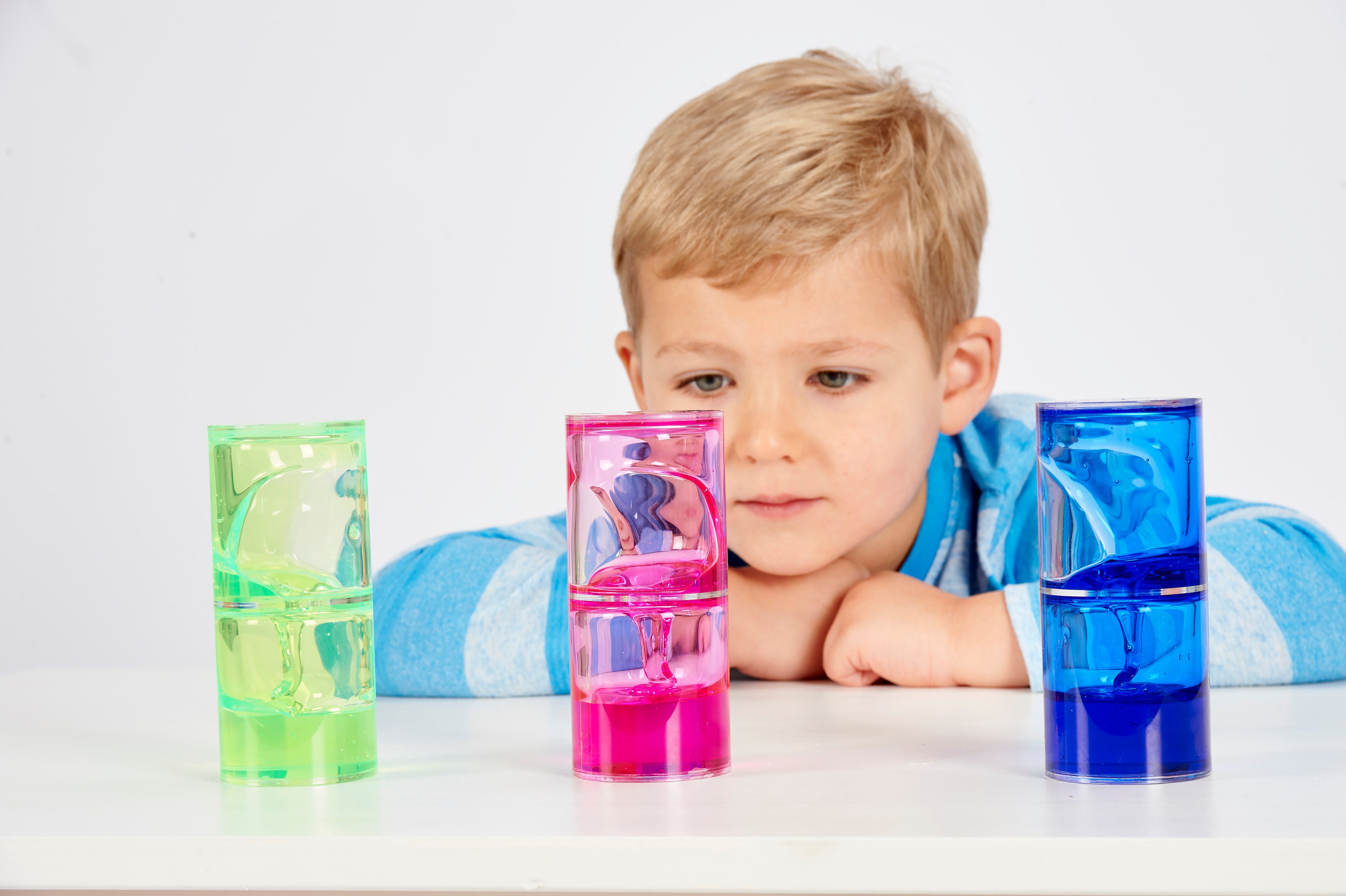 Ooze tube set with green, pink, and blue translucent tubes with child behind