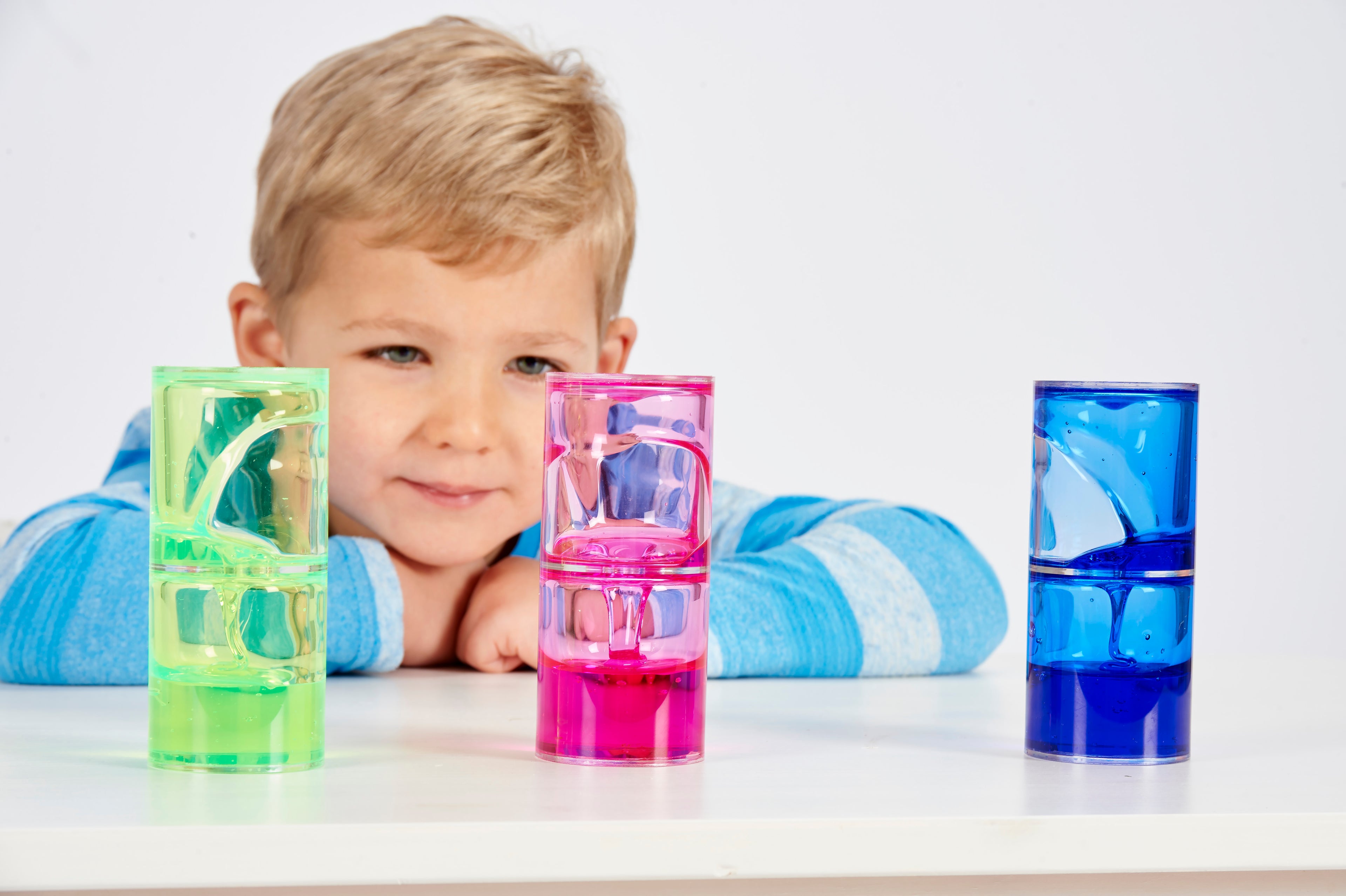 Ooze tube set with green, pink, and blue translucent tubes in front of child