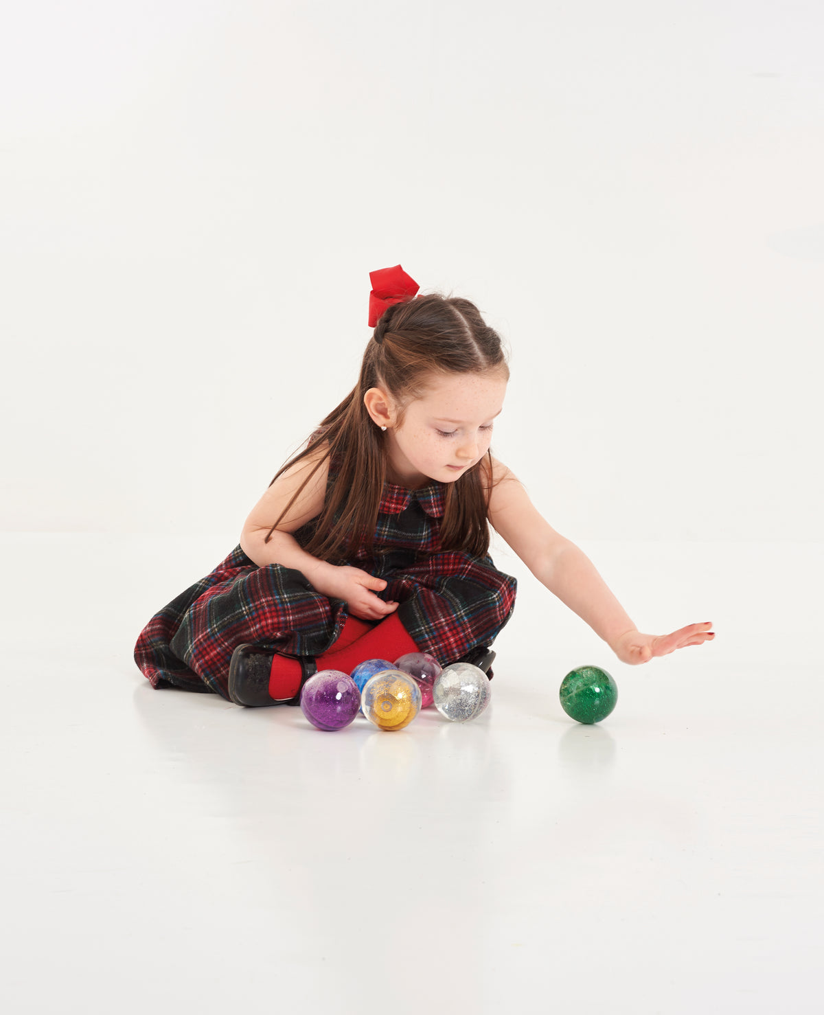Scattered glitter sensory balls in mixed colors with a child playing