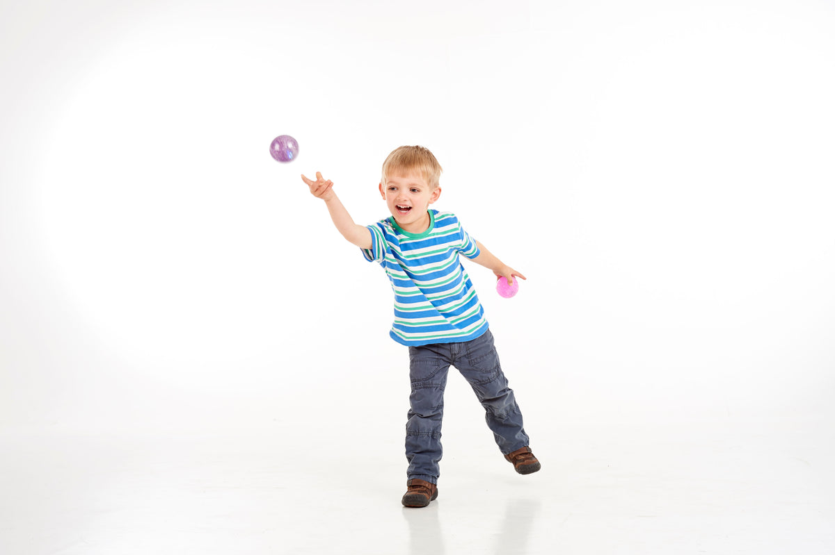 Glitter sensory ball in purple, held by a child for play