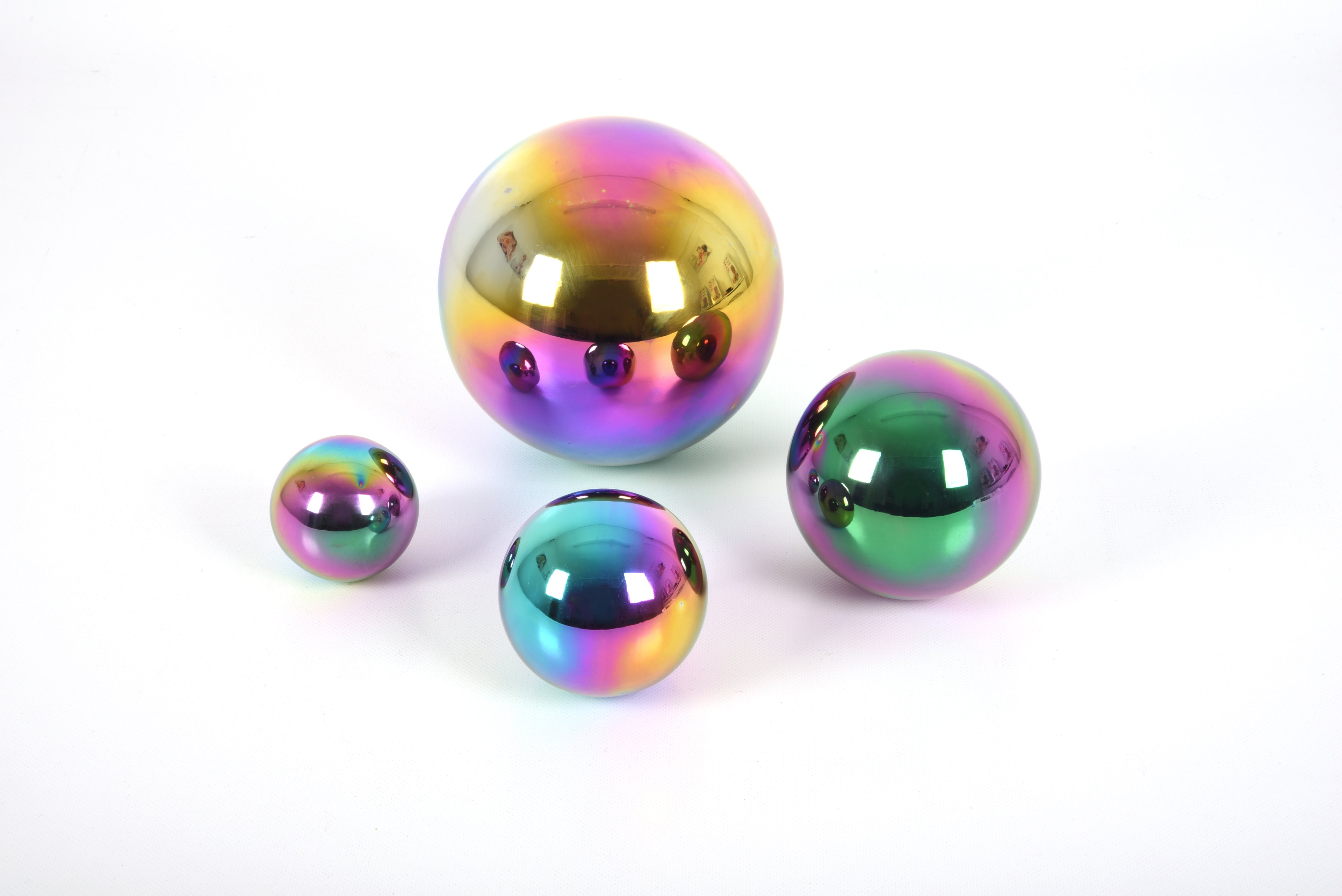 Set of four iridescent metallic balls with rainbow mirror finish, one large and three small