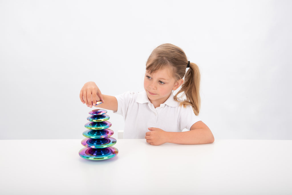 Iridescent steel buttons set of 7, tall stack beside child at table