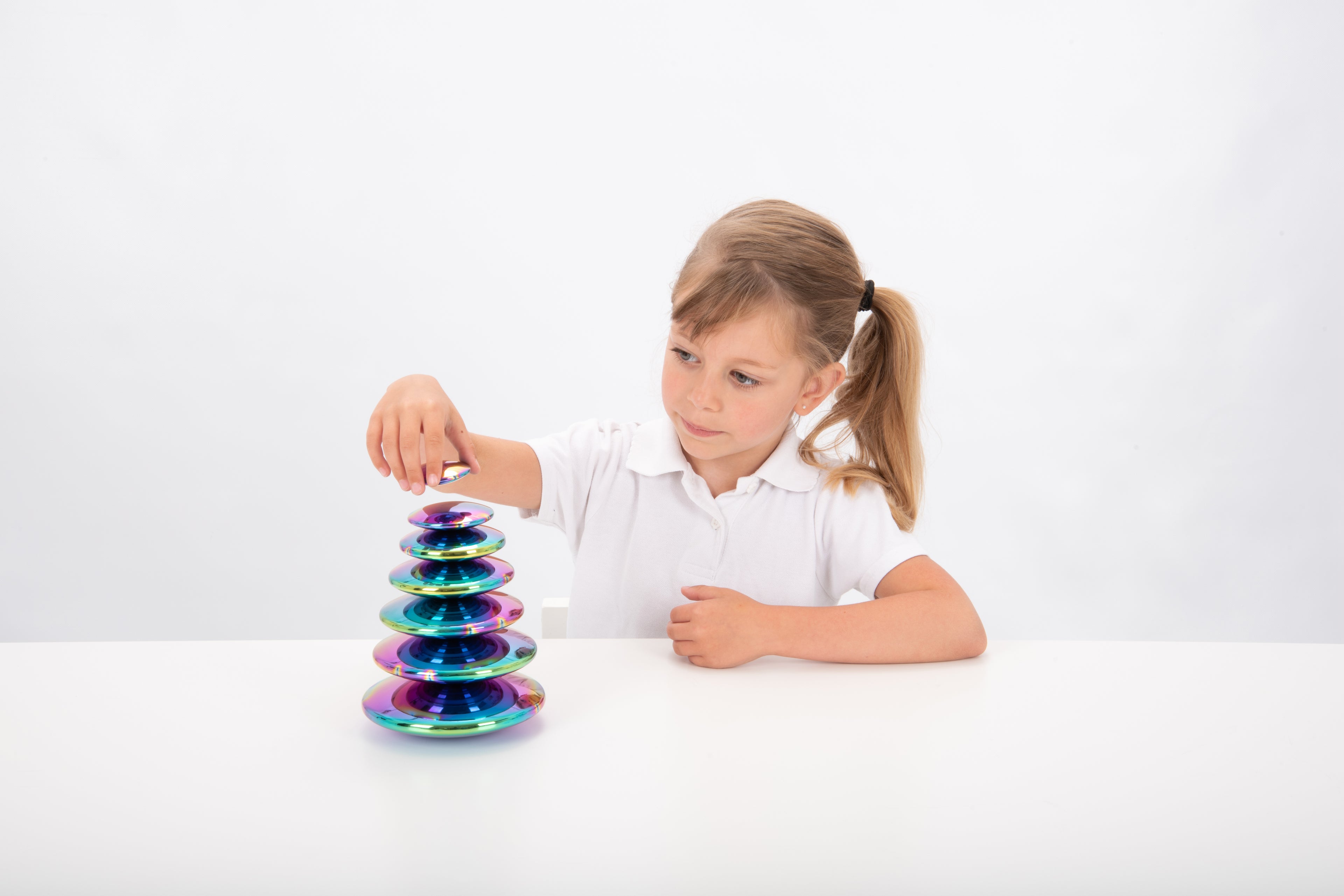 Iridescent steel buttons set of 7, tall stack beside child at table