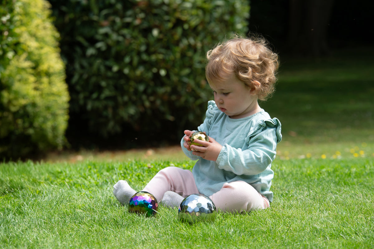 Iridescent metallic mosaic sensory balls in a child’s hands, 3-ball set