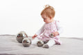 Set of shiny silver steel sensory balls with reflective surfaces; baby kneeling and playing