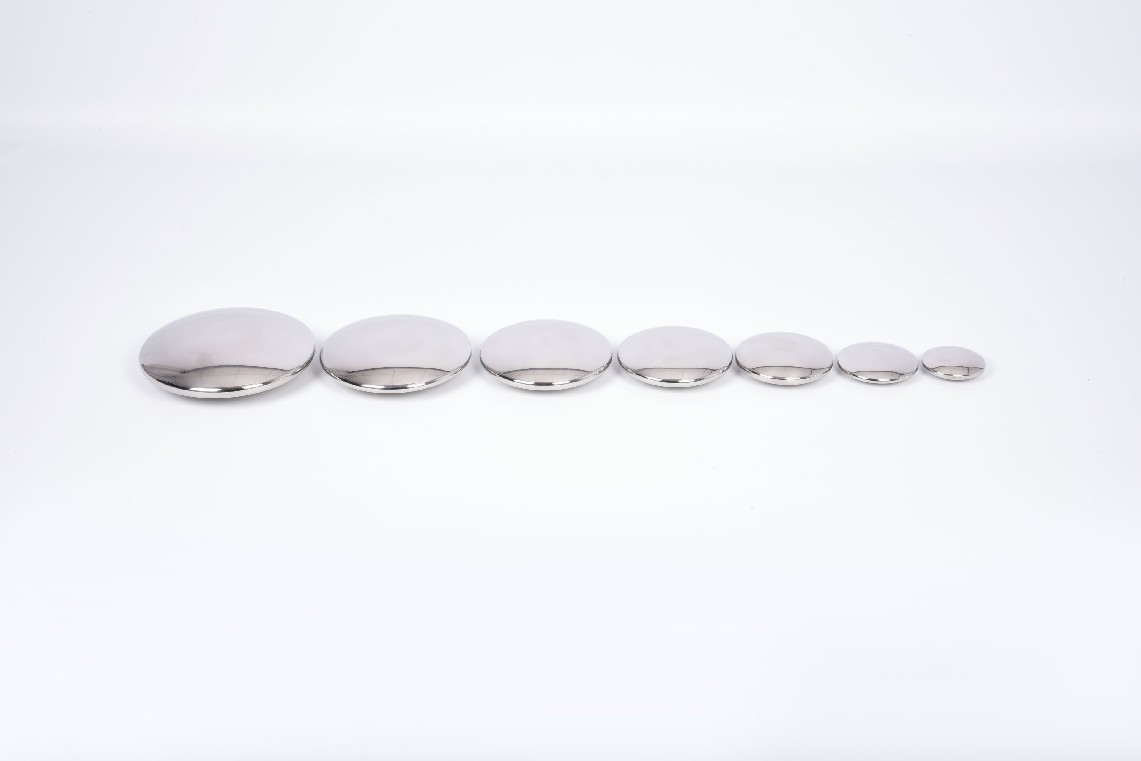 Seven round silver sensory metal buttons in a straight row