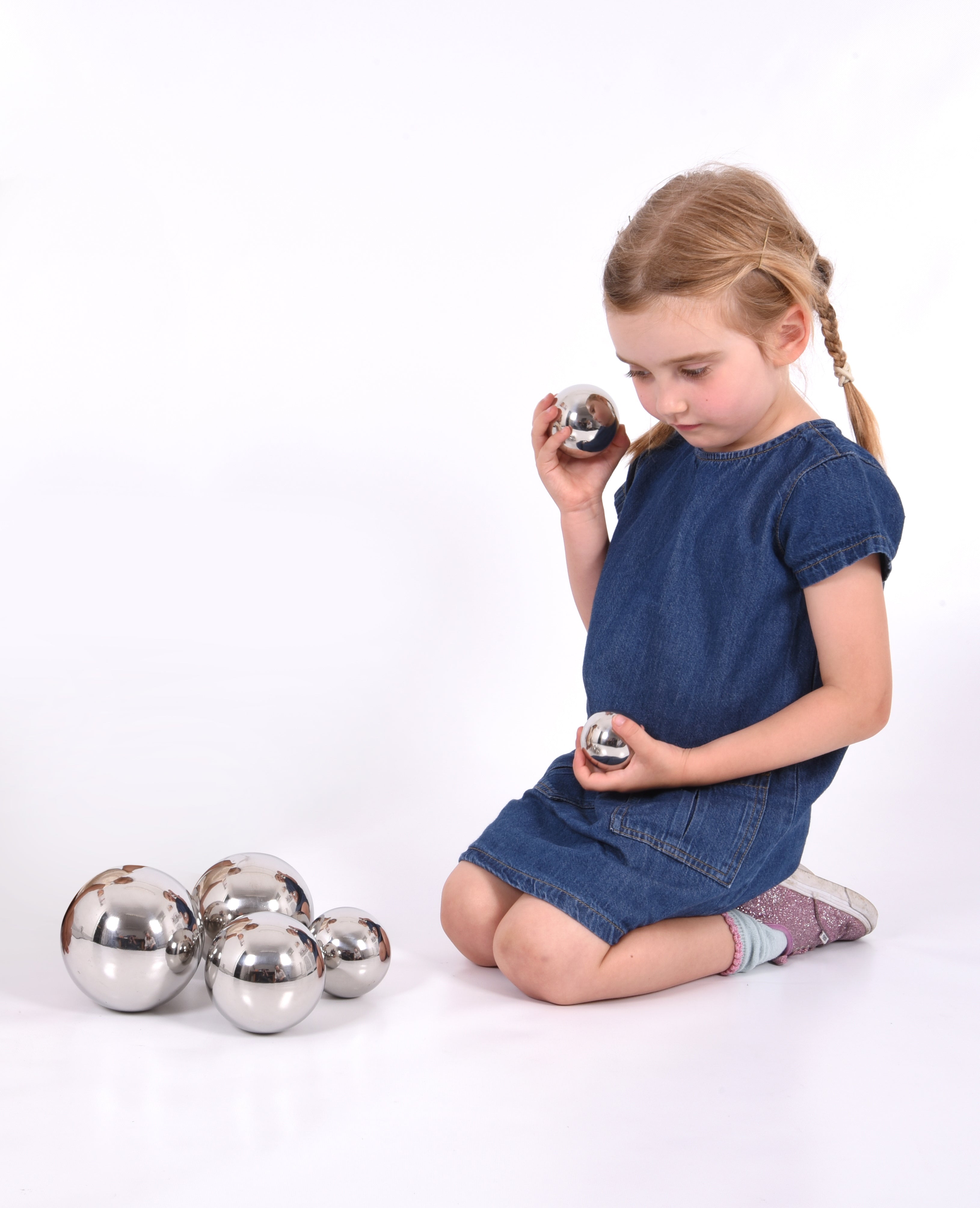 Set of 7 shiny silver steel sound balls, with a child holding one