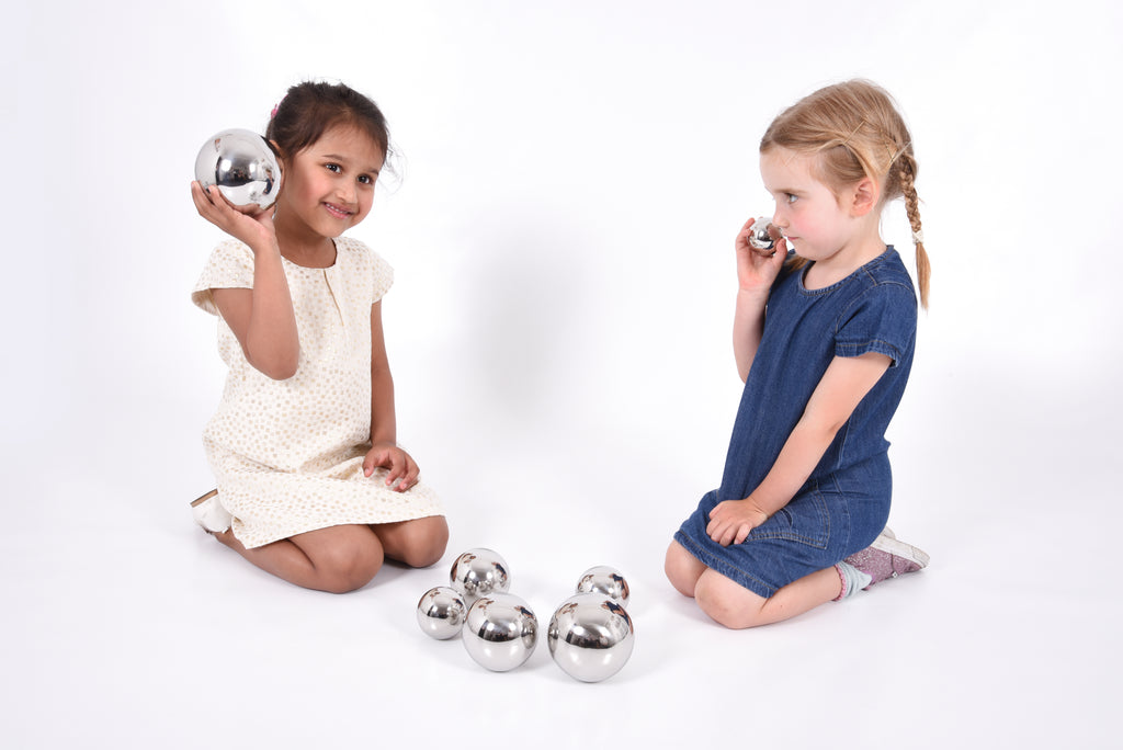 Set of 7 shiny silver steel sound balls, two children holding one each