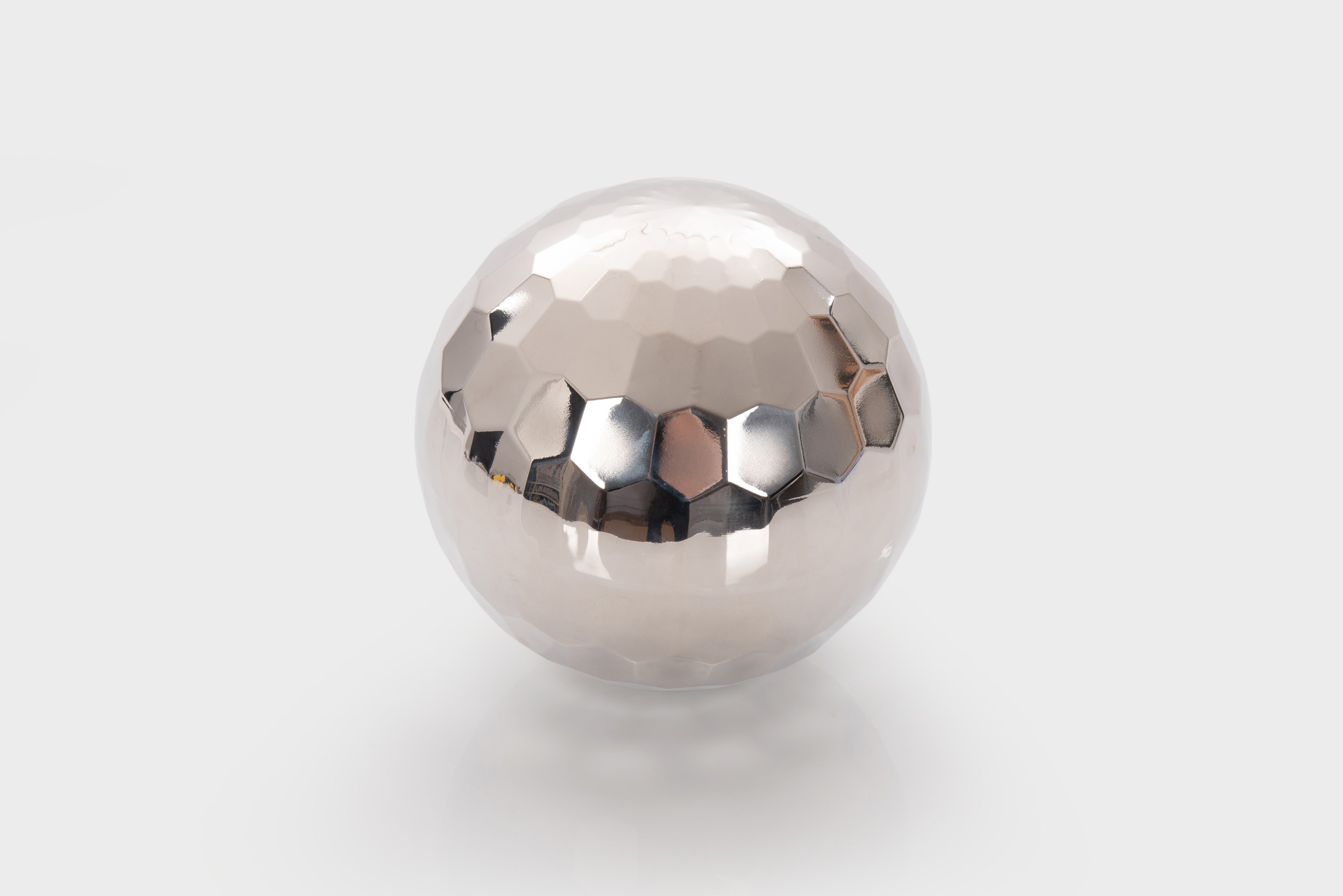 Reflective silver steel tumble ball with faceted mirrored surface