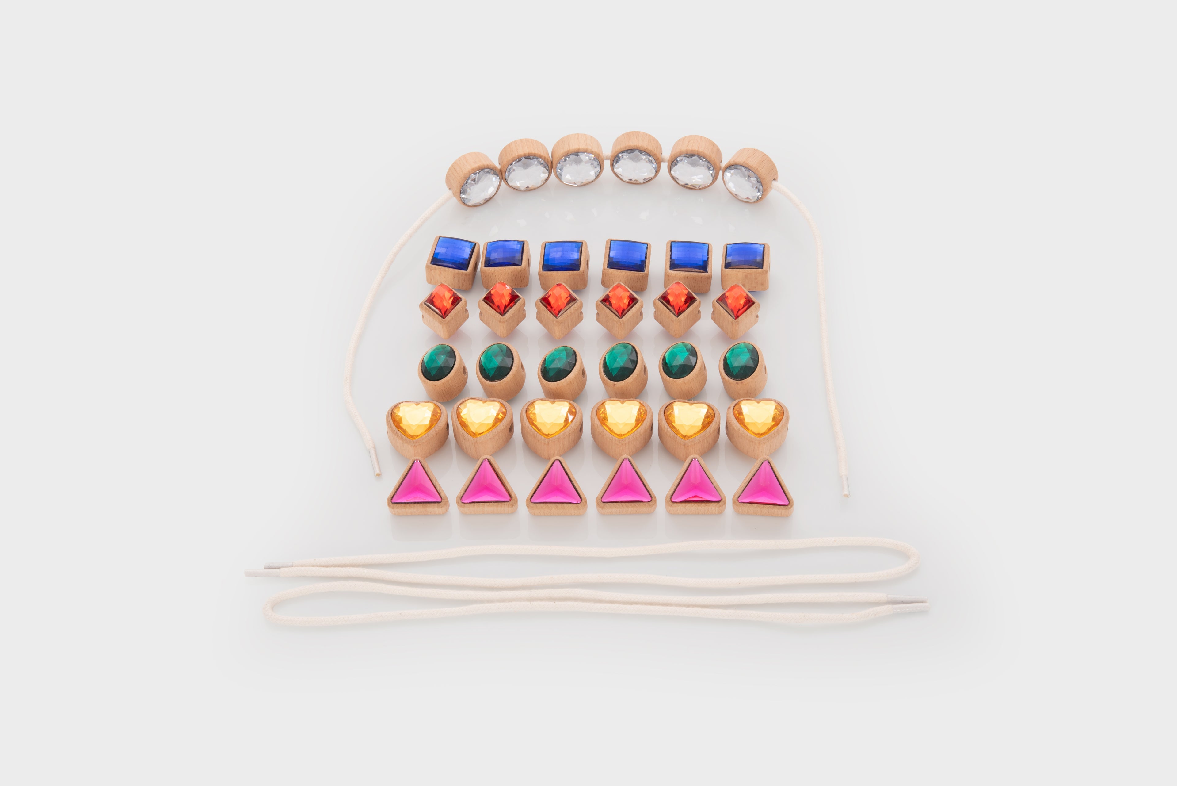 White cord lacing jewels with blue squares, green ovals, pink triangles and orange heart beads