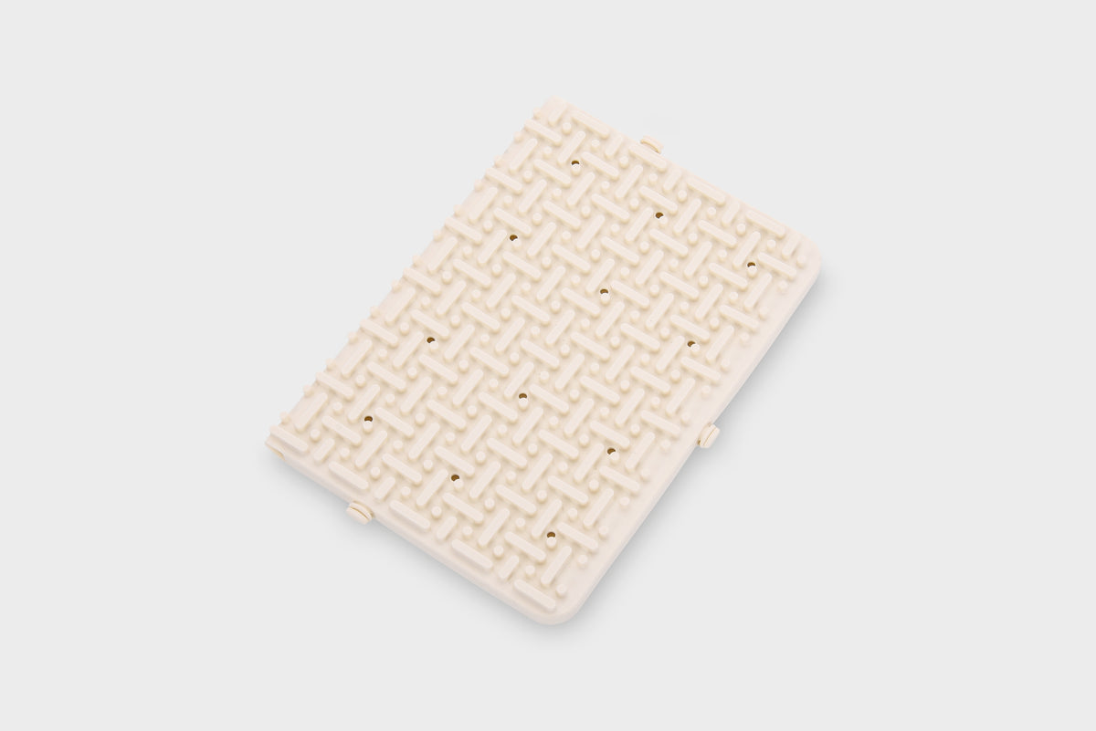 Beige activity maze board with woven grid pattern and small pegs