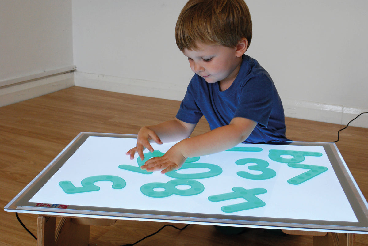 Green dot number tiles on a white board for learning play