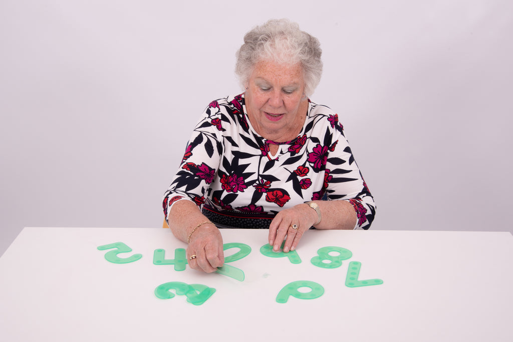 Adult placing green dot number tiles on a tabletop