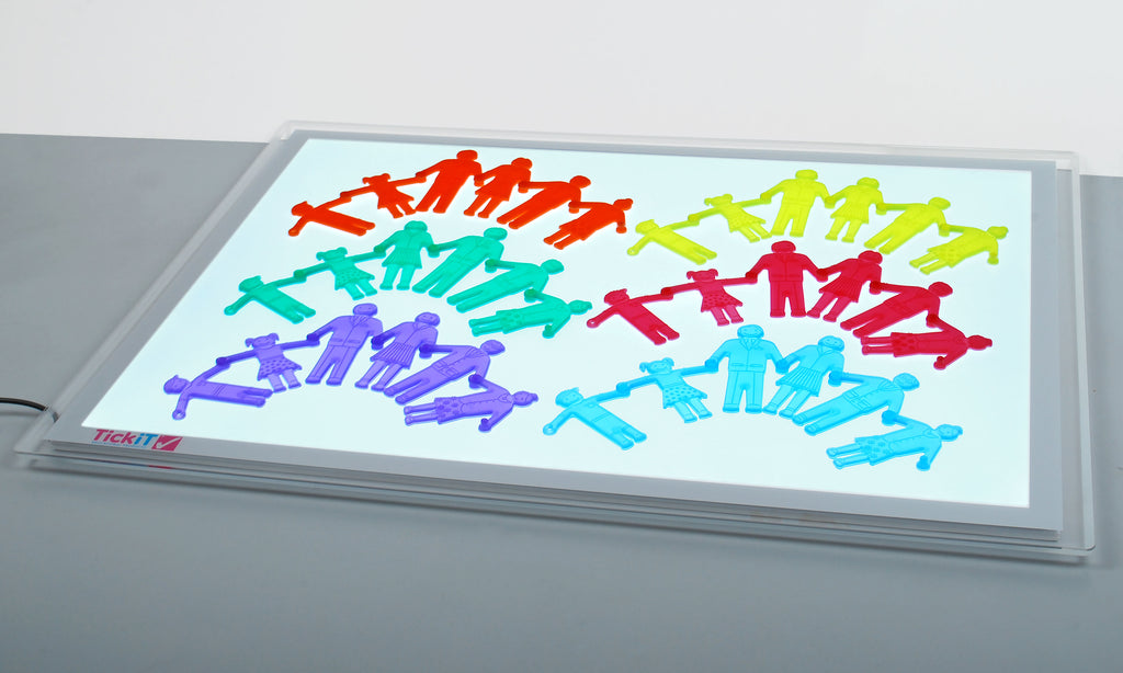 Colorful plastic people puzzle pieces on a clear tabletop board, assorted poses