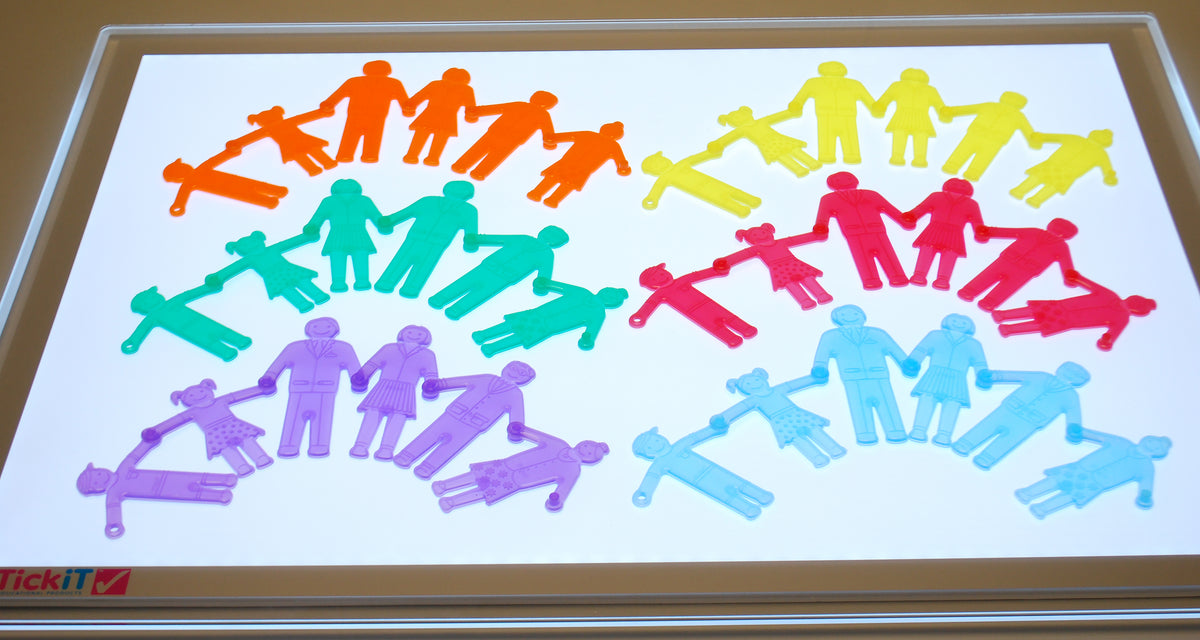 Colorful plastic people toy pieces on a framed clear board, rainbow assortment