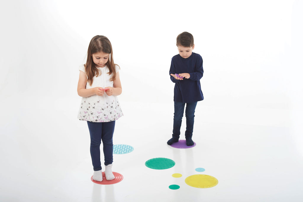 Kids stepping on colorful sensory circles with round textured surfaces