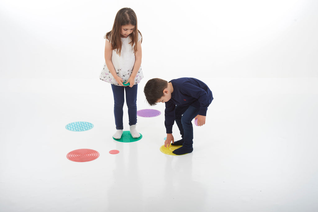 Colorful sensory stepping circles for kids, scattered on the floor