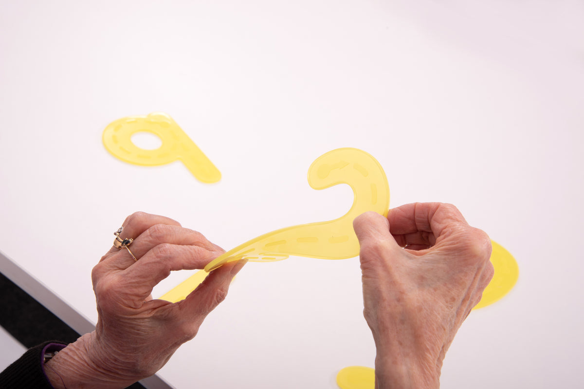 Hands holding and placing yellow foam trace numbers, digit pieces visible