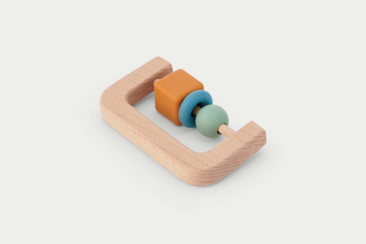 Wooden arch baby rattle with orange, teal, and cream beads on a light wood base