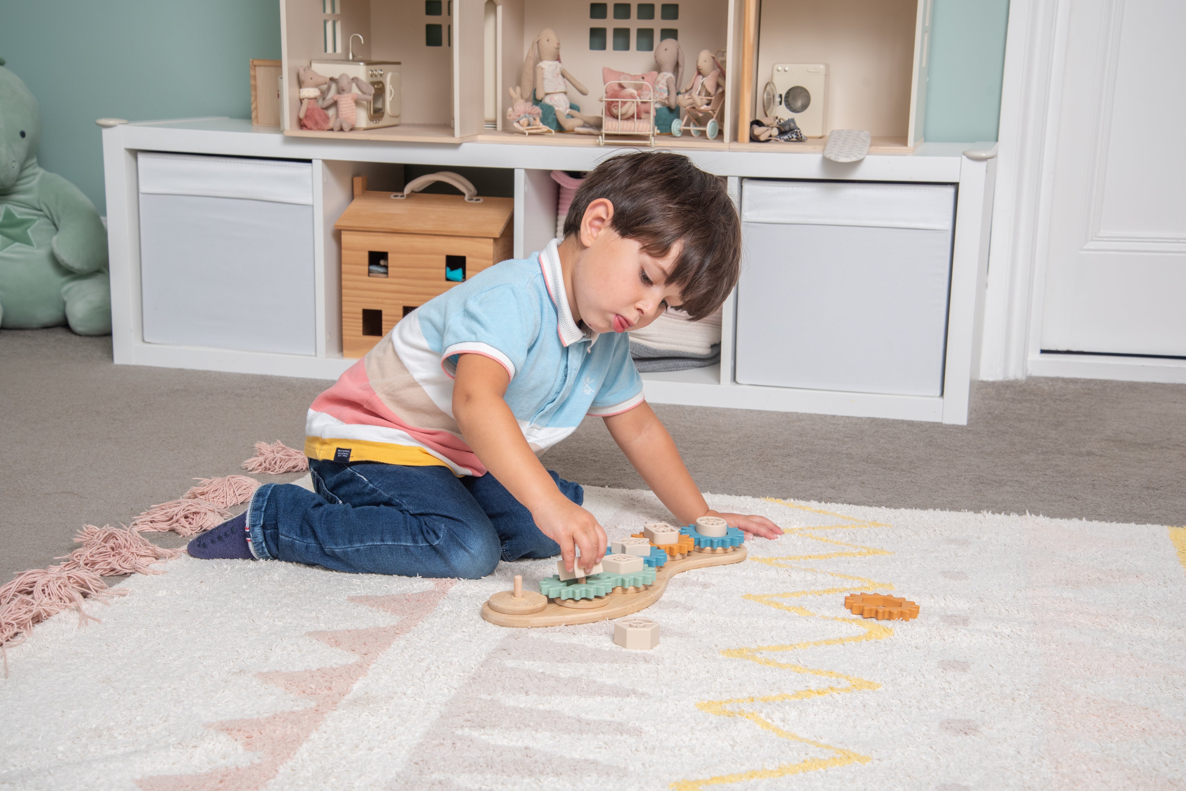 Silisoft Gears puzzle on play mat with orange and blue gear tiles on wooden base