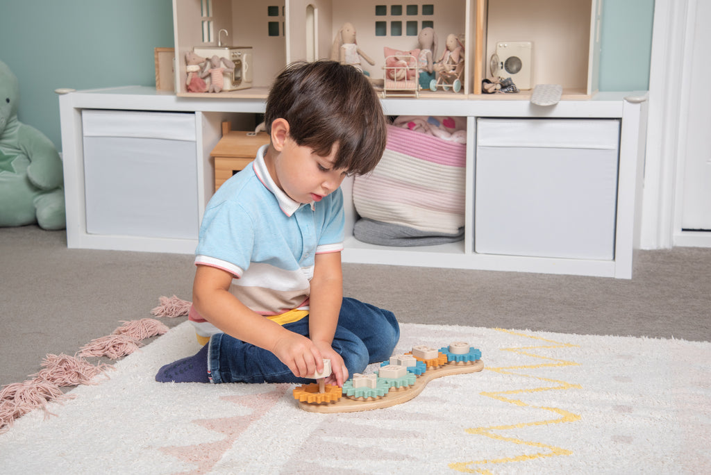Silisoft Gears puzzle with gear pieces on curved wooden base, child playing