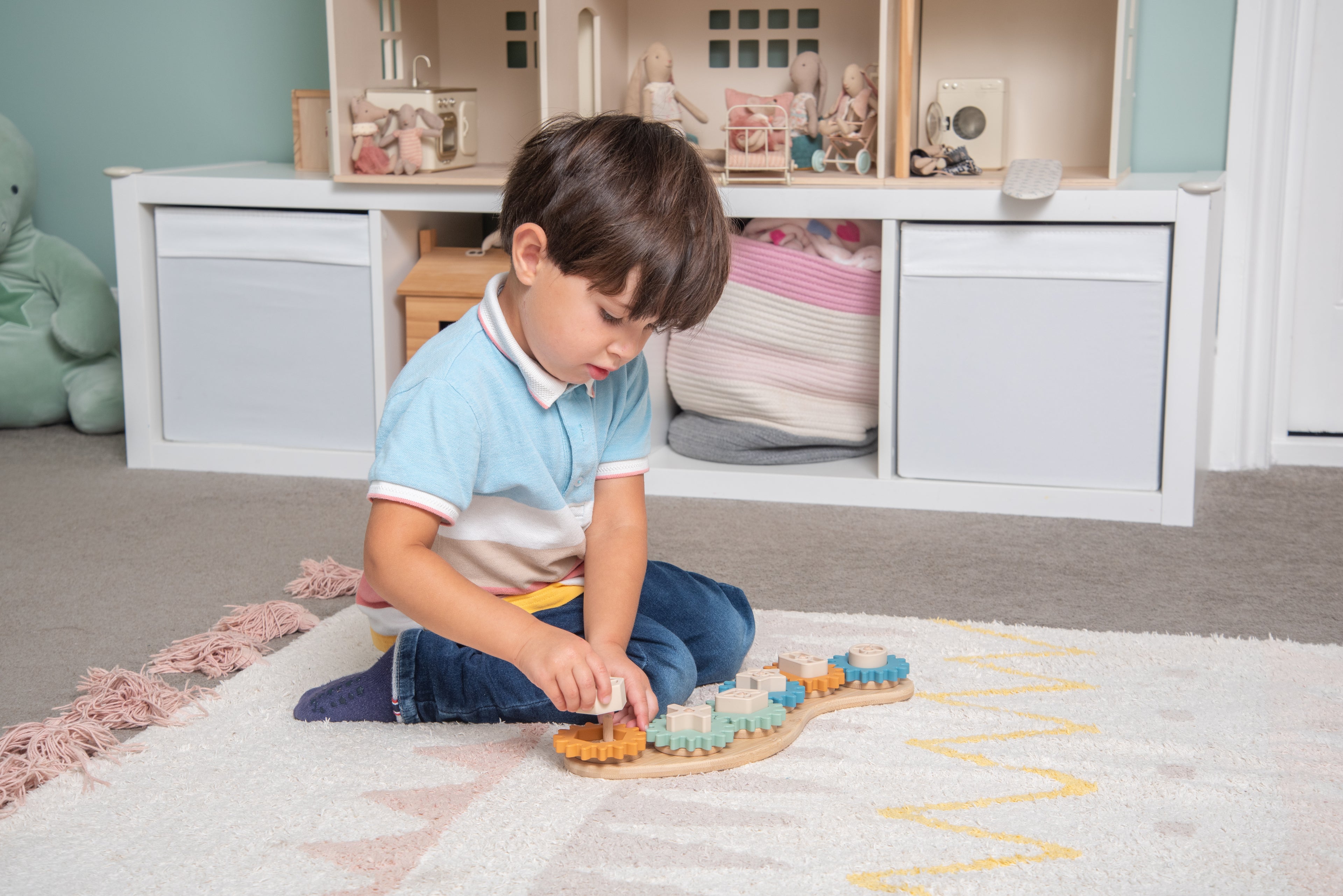 Silisoft Gears puzzle with gear pieces on curved wooden base, child playing