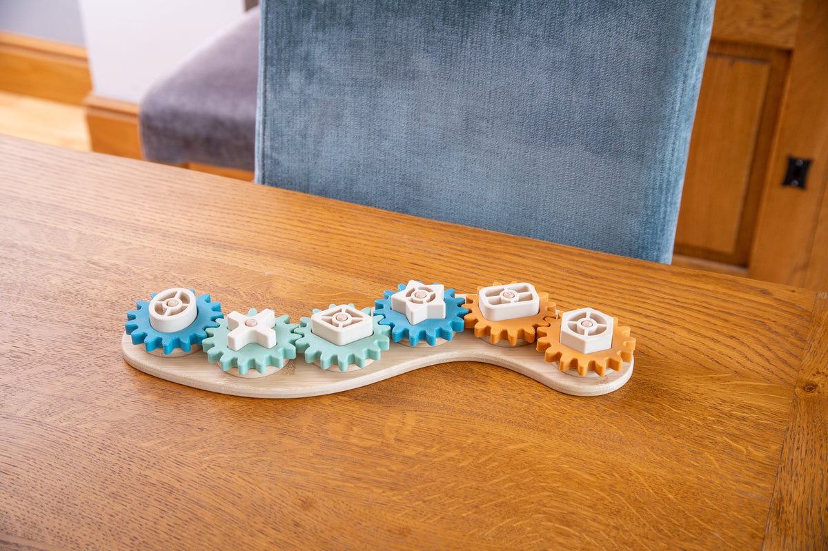 Silisoft Gears puzzle close-up on table: blue, tan, and orange gear pieces