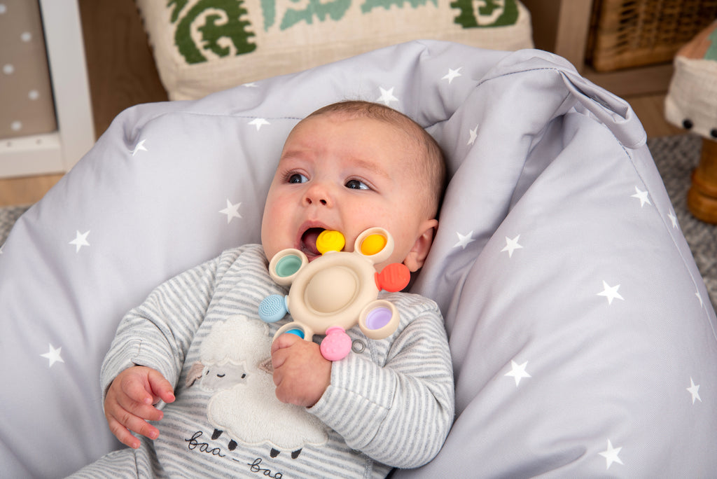 Rainbow silicone pop teether with beige center and multi-color pop rings