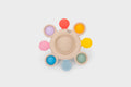 Beige silicone pop teether with colorful rings and a textured thumb pad