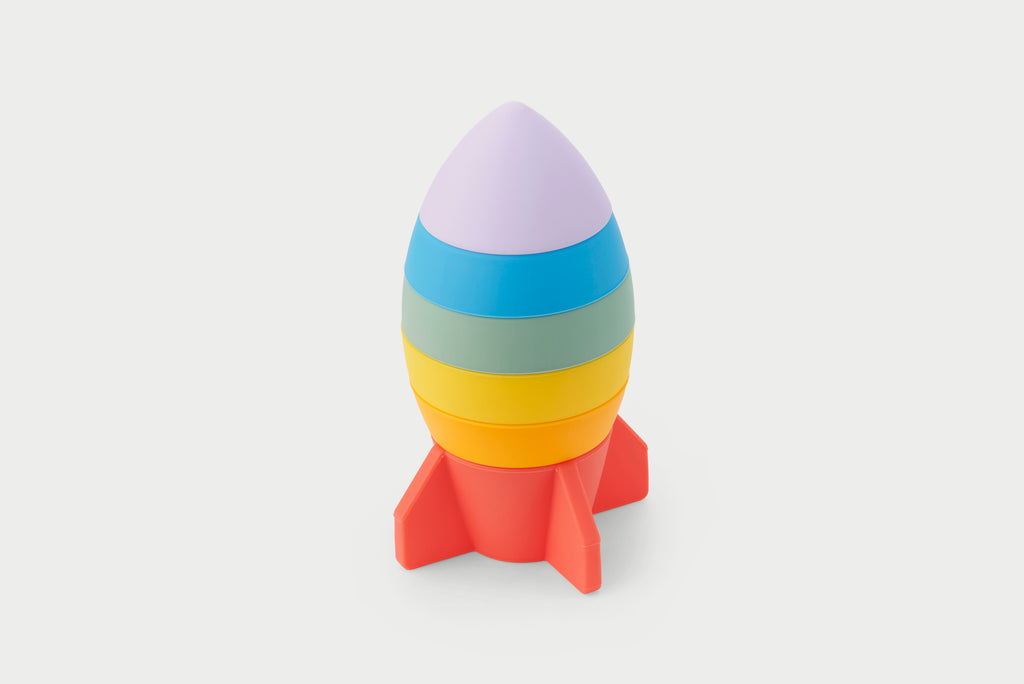 Rainbow rocket stacker toy with layered rings and red fins, no person.