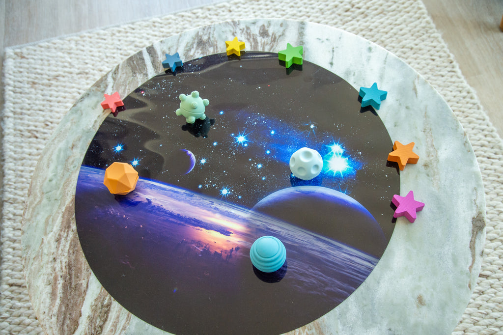Sensory ball set on round play mat with blue, mint, and orange star pieces