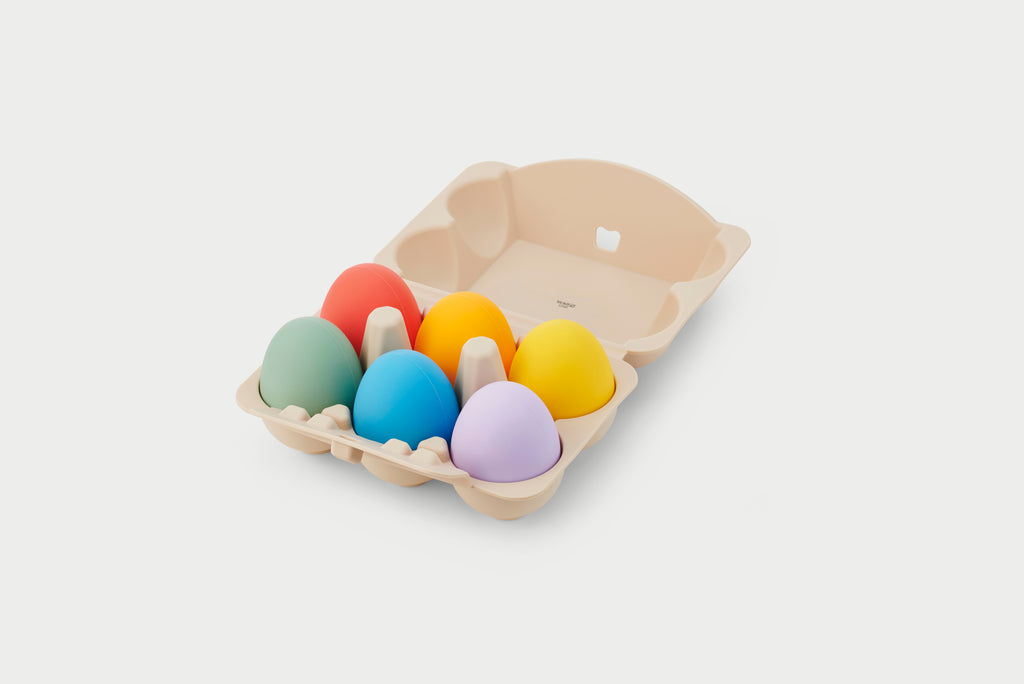 Rainbow sensory eggs set in beige molded tray, featuring colorful egg shapes