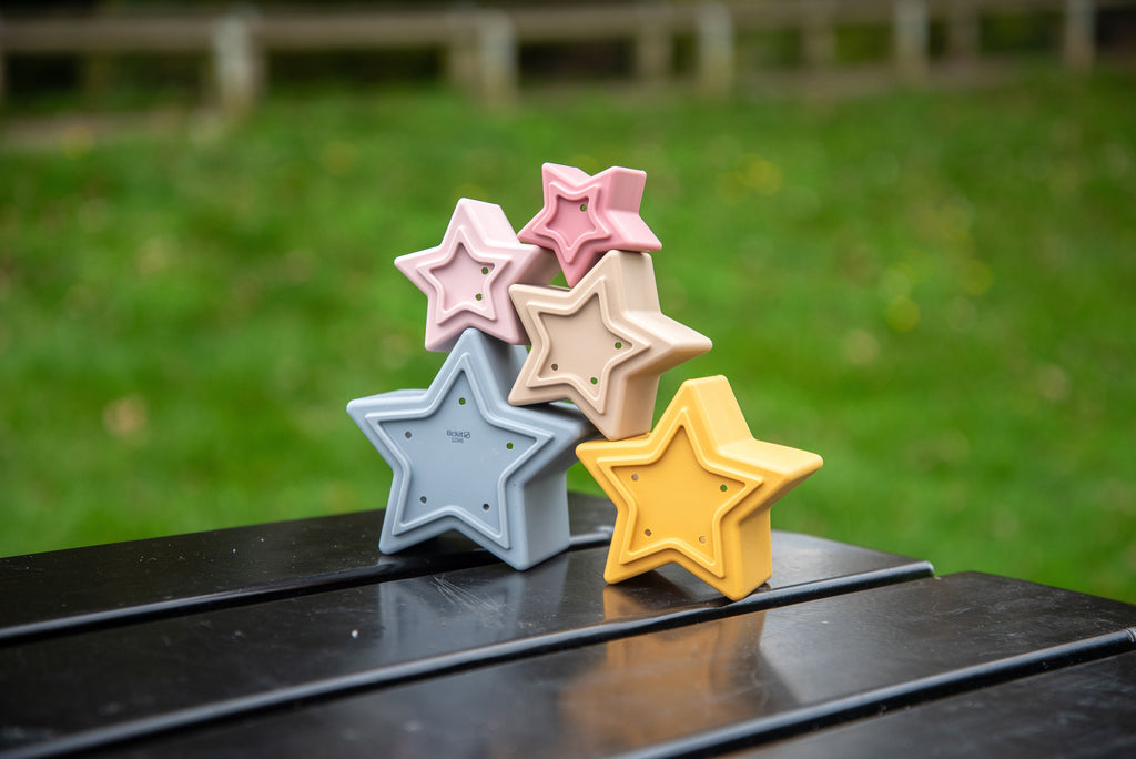 Stacking star cups set with five star shapes in pink, beige, blue, and yellow.